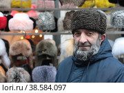 Курбан из Дагестана продаёт головные уборы на Измайловском Вернисаже (2022 год). Редакционное фото, фотограф Дмитрий Неумоин / Фотобанк Лори
