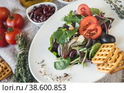 Salad diet for weight correction from the leaves of Lollo Rosso lettuce, watercress salad and other green herbs with tomatoes, olives and fitaki. Close up. Стоковое фото, фотограф Оксана Медведева / Фотобанк Лори