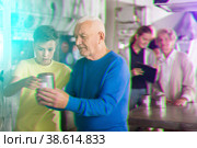Grandson together with his grandfather solve the riddles of quest room. Стоковое фото, фотограф Яков Филимонов / Фотобанк Лори