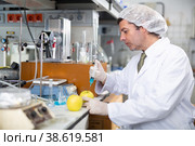 Geneticist working in laboratory, injecting additives into apple during experiments with genetically modified apple. Стоковое фото, фотограф Яков Филимонов / Фотобанк Лори
