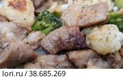 Мясо с брокколи и цветной капустой. Сочное вкусное жареное мясо с овощами. Изысканное азиатское блюдо на сковороде. Крупный план, вращение. Meat with broccoli and cauliflower. Juicy delicious fried meat with vegetables. An exquisite Asian dish in a frying pan. Close-up, rotation. Стоковое видео, видеограф Ирина / Фотобанк Лори