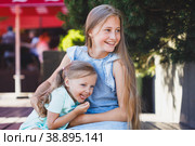 two sisters sitting tickling and laughing. Стоковое фото, фотограф Поликарпов Владимир Владимирович / Фотобанк Лори