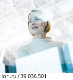 Portrait of strong, determined, successful young woman looking trough window while waiting to board an airplane at airport terminal departure gates. Стоковое фото, фотограф Matej Kastelic / Фотобанк Лори