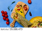 Greek appetizer, pita with chicken meat, vegetables and sauce. Close-up on a blue background, overhead. Стоковое фото, фотограф Bogdanova Mariia / Фотобанк Лори