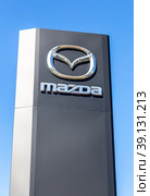 Mazda dealership sign against a blue sky background (2022 год). Редакционное фото, фотограф FotograFF / Фотобанк Лори