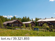 June 8, 2015 - Scene from a Russian village overlooking a colorful log house with traditional wood trim, Mandrogi, Russia. Редакционное фото, фотограф Оксана Медведева / Фотобанк Лори