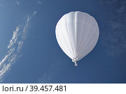 A Chinese-made white meteorological probe is shown flying in the sky, violating the airspace in its pursuit of atmospheric reconnaissance and research. Стоковое AI-изображение, AI-художник Владимир Разгуляев / Фотобанк Лори
