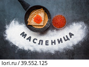 Русские традиции. Широкая масленица. Улыбка. Сковородка, блинчики и красная икра. Надпись на русском языке - "Масленица". Написано мукой. Вид сверху. Стоковое фото, фотограф Photojuli / Фотобанк Лори