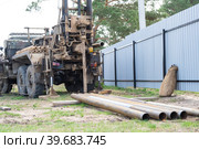 Drilling rig on zil car are drilling artesian well for water in ground. Insertion of metal casing pipe into ground, installation of individual drinking supply. Стоковое фото, фотограф Ольга Симонова / Фотобанк Лори