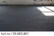 The leveled rough floor in a house under construction with a semi-dry cement screed is a smooth surface with light from the windows. Стоковое фото, фотограф Ольга Симонова / Фотобанк Лори