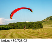 Мотопараплан с пилотом и пассажиром совершает взлёт. A paramotor with a pilot and a passenger takes off (2022 год). Редакционное фото, фотограф Евгений Романов / Фотобанк Лори