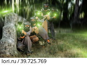 Paintball players of one team in camouflages and masks aiming with gun in shootout. Стоковое фото, фотограф Яков Филимонов / Фотобанк Лори