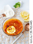Мясная Солянка. сборная солянка. порция острого красного мясного супа с помидорами, копченостями сосисками и оливками с лимоном на светлом фоне. Стоковое фото, фотограф Оксана Медведева / Фотобанк Лори