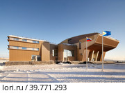 Здание Музейного центра "Наследие Чукотки" и Чукотского окружного дома народного творчества, Анадырь, Чукотка, Россия. На центральной площади установлены флаги России и Чукотки. Крайний Север, Арктика. Редакционное фото, фотограф Андрей Степанов / Фотобанк Лори