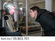 На ВДНХ в павильоне №2 "Робостанция" мужчина общается с социоботом  - роботом, созданным воспроизводить любые человеческие эмоции (2021 год). Редакционное фото, фотограф Наталья Николаева / Фотобанк Лори