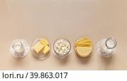 Flat lay of fresh dairy products - milk, cottage cheese, yogurt, sour cream and butter on light pastel background. Organic farm natural healthy food. Empty space for text. Top view, closeup, mock up. Стоковое фото, фотограф Виктория Катьянова / Фотобанк Лори