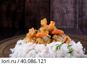 Fish curry with codfish, pollack and shrimps with coconut milk served on rice on brown plate. Стоковое фото, фотограф Оксана Чаюн / Фотобанк Лори