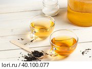 Two glass cups of Kombucha tea, a sweet and sour carbonated drink originally from China. On a light wooden background. Стоковое фото, фотограф Bogdanova Mariia / Фотобанк Лори