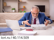 Old male employee in remuneration concept at home. Стоковое фото, фотограф Elnur / Фотобанк Лори