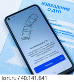 Смартфон с открытым приложением Госуслуги Авто ни бланке извещения о ДТП (2023 год). Редакционное фото, фотограф Анна Аникова / Фотобанк Лори