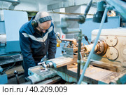 Worker turner operating lathe machine (2019 год). Редакционное фото, фотограф Сергей Буторин / Фотобанк Лори