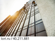 Industry mountaineering workers hangs on residential facade building. Rope access laborers on wall house, washing exterior facade glazing. Concept of industry urban works. Copy advertising text space. Стоковое фото, фотограф Aleksandr Golubev / Фотобанк Лори