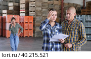 European man and woman discusisng loading plan at the warehouse. Стоковое видео, видеограф Яков Филимонов / Фотобанк Лори