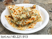 Gozleme. A traditional dish of Turkish cuisine in the form of flatbread stuffed with greens and cheese, wrapped inside. Baked in a pan called a saj. Selective focus. Стоковое фото, фотограф Виктория Панченко / Фотобанк Лори