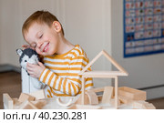 Маленький мальчик 3 лет играет в развивающий логистический конструктор. Детские деревянные игрушки. Монтессори для развития ребенка. Стоковое фото, фотограф Photojuli / Фотобанк Лори