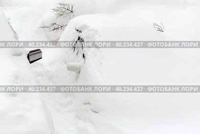 Автомобили под снегом. На улице много снега и большие сугробы. Машины полностью засыпаны снегом после снежного шторма. Холодная зимняя погода. Последствия сильной пурги, метели и снегопада. Стоковое фото, фотограф Андрей Степанов / Фотобанк Лори
