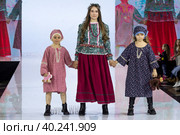 Модели демонстрируют казачий национальный костюм на подиуме в рамках шоу "Грани Мира" на фестивале детской моды Kids Fashion Week в "Центральном детском магазине на Лубянке" (ЦДМ) в Москве, Россия (2023 год). Редакционное фото, фотограф Николай Винокуров / Фотобанк Лори