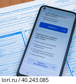 Смартфон с открытым приложением Госуслуги Авто на бланке извещения о ДТП. Стоковое фото, фотограф Анна Аникова / Фотобанк Лори