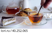 Hand stirs a teaspoon of sugar in a cup. Breakfast with cake. Стоковое видео, видеограф Ирина Толокновская / Фотобанк Лори