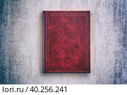 The book in a red cover over gray grunge background, top view with vignette. Стоковое фото, фотограф Андрей С / Фотобанк Лори