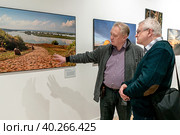 Участник фотовыставки Евгений Кулешов у своих работ. Редакционное фото, фотограф Андрей Дегтярёв / Фотобанк Лори
