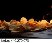 Fried potato chips on a black background. The illustration was created by AI. Стоковое AI-изображение, AI-художник Ярославский Максим / Фотобанк Лори