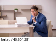 Young male employee working from home during pandemic. Стоковое фото, фотограф Elnur / Фотобанк Лори