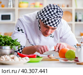 Young male cook working in the kitchen. Стоковое фото, фотограф Elnur / Фотобанк Лори