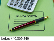 Калькулятор и шариковая ручка на книге учета. Стоковое фото, фотограф Анна Аникова / Фотобанк Лори