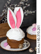 Beautiful stylish still life. Easter cake with rabbit ears, meringue, marshmallows, Easter eggs and willow twigs on a dark background. happy Easter. Стоковое фото, фотограф Photojuli / Фотобанк Лори