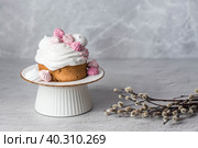 Beautiful stylish still life. Easter cake with meringue, marshmallows, Easter eggs and willow twigs on a light concrete background. happy Easter. Стоковое фото, фотограф Photojuli / Фотобанк Лори