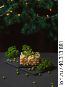 Olivier salad on a dark background in an interesting form of serving and decoration for the New Year and Christmas, with copy space. Стоковое фото, фотограф Неведицына Елена / Фотобанк Лори