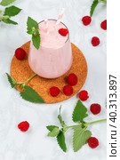 Milkshake with raspberries in a glass glass with melissa leaves in the design. Стоковое фото, фотограф Неведицына Елена / Фотобанк Лори