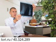Male physician sitting in office and looking at roentgenogram. Стоковое фото, фотограф Яков Филимонов / Фотобанк Лори