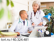 Two physicians working with case histories on laptop in office. Стоковое фото, фотограф Яков Филимонов / Фотобанк Лори