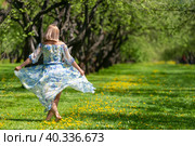 Стройная девушка в платье танцует босиком на траве и цветах в весеннем саду. Стоковое фото, фотограф Pukhov K / Фотобанк Лори