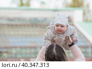 Cute little boy playing with his mom outside. A happy child is tossed up in the park. The kid laughs merrily. Portrait of a boy. Mothers Day. Стоковое фото, фотограф Photojuli / Фотобанк Лори