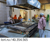 Приготовление еды для паломников в храме Gurudwara Sri Bangla Sahib (Нью Дели, Индия) (2023 год). Редакционное фото, фотограф Максим Гулячик / Фотобанк Лори