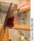 An old man paints a wooden, exotic, old chair in a brush. Стоковое фото, фотограф Александр Кротков / Фотобанк Лори