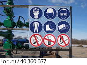 Предупредительные, предписывающие и запрещающие знаки на ограждении фонтанной арматуры газовой скважины. Стоковое фото, фотограф Игорь Дашко / Фотобанк Лори